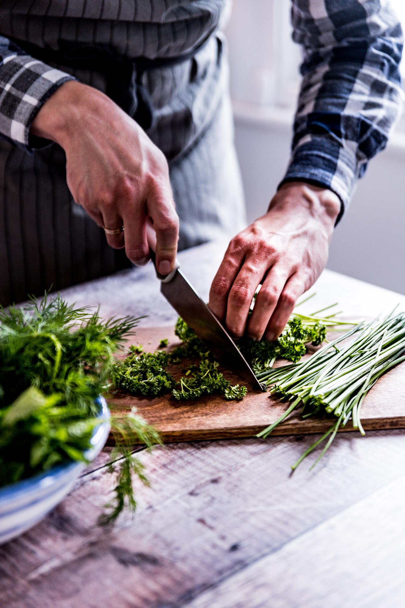 Dettaglio di mani che tagliano erbe fresche